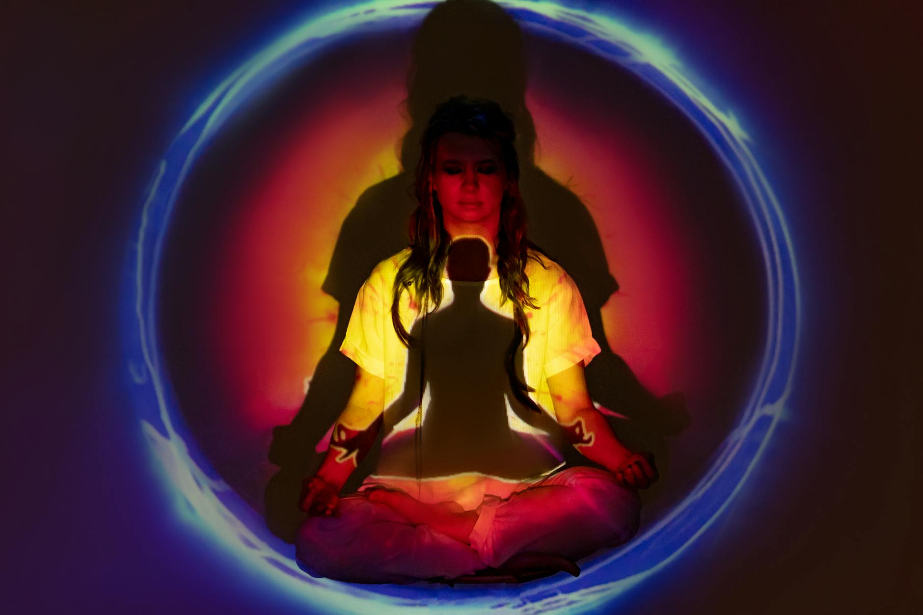 Woman in a calm meditation pose surrounded by mint-colored light.